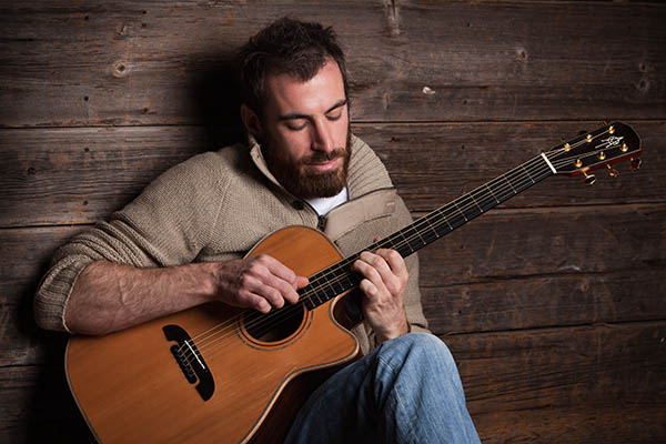 Kenny playing acoustic guitar